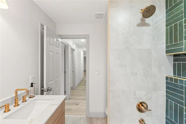a bathroom with a sink mirror and shower