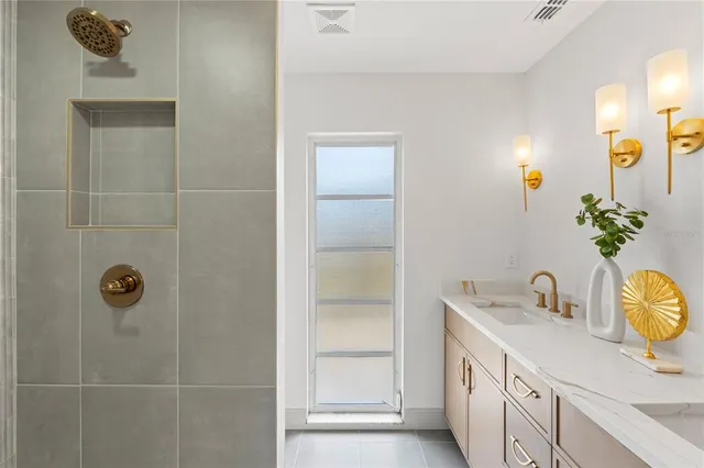 a bathroom with a sink a light fixture and a shower