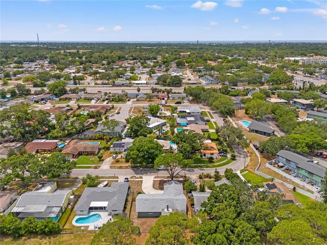 an aerial view of residential houses with outdoor space and trees