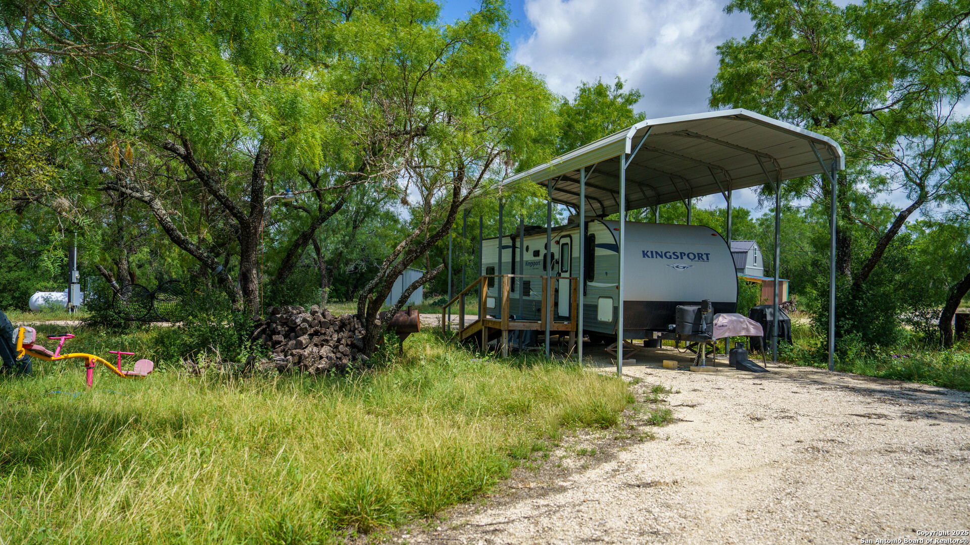 1231 B & R Road Vanderpool, TX 78885 - Photo 7 of 26 a backyard of a house with table and chairs under an umbrella