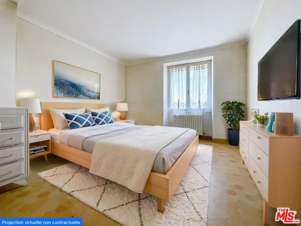 a bedroom with a bed and a flat screen tv