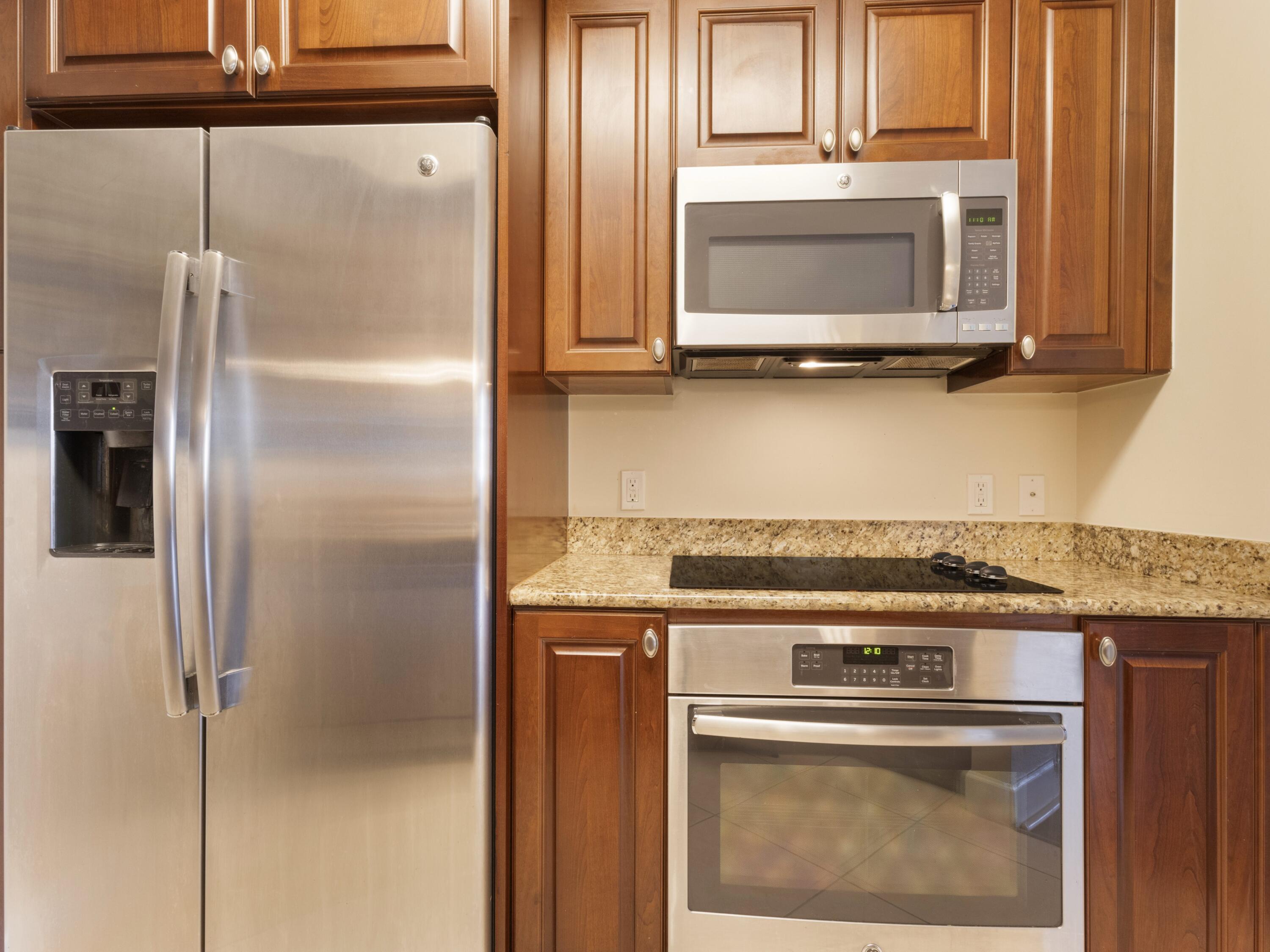 1690 Renaissance Commons Boulevard, Unit 1412 Boynton Beach, FL 33426 - Photo 5 of 49 a kitchen with a refrigerator and a microwave