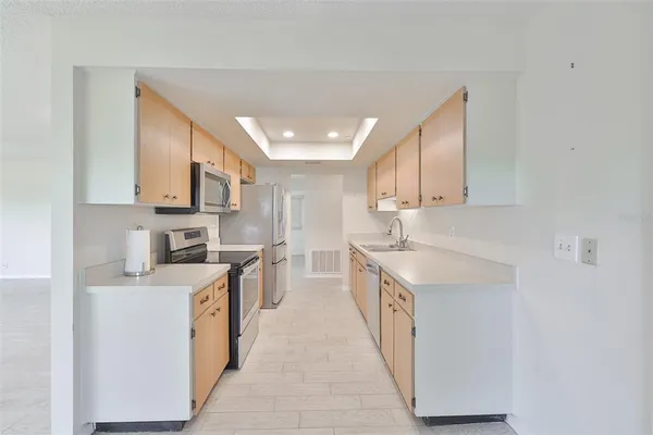a kitchen with stainless steel appliances granite countertop a sink and dishwasher a stove top oven with wooden floor