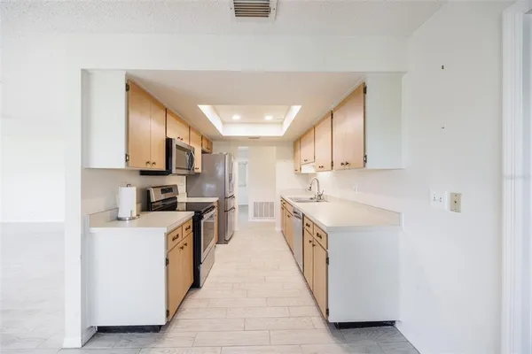 a kitchen with stainless steel appliances granite countertop a sink and dishwasher a stove top oven with white cabinets