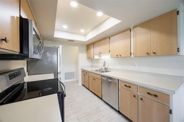 a kitchen with stainless steel appliances granite countertop a stove a sink and a refrigerator