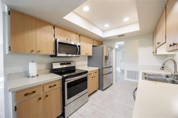 a kitchen with stainless steel appliances granite countertop a refrigerator and a sink