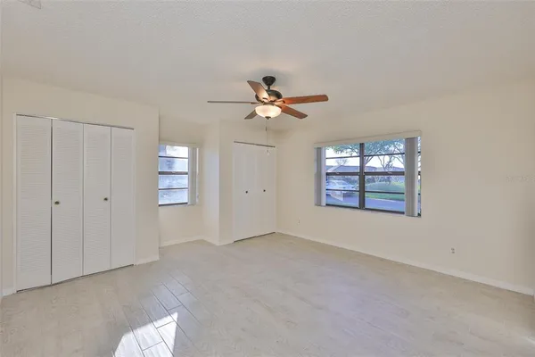 an empty room with closet and a ceiling fan