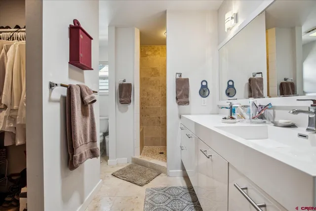 a spacious bathroom with a double vanity sink a mirror a shower and a glass door