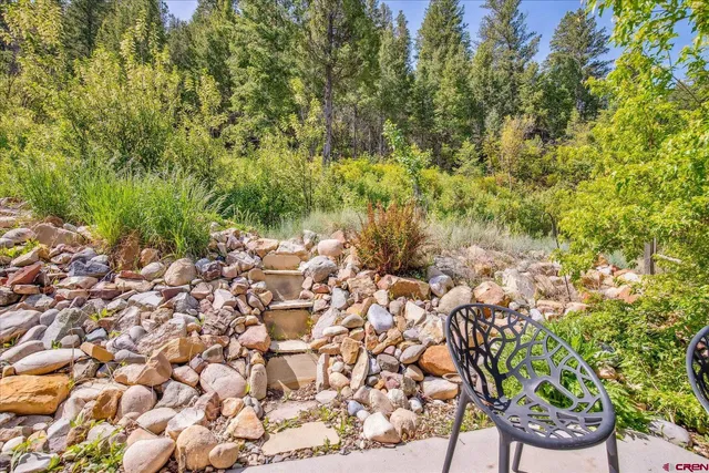 a view of a yard with plants and wooden fence