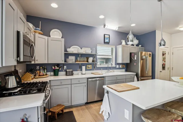 a kitchen with stainless steel appliances sink stove refrigerator and cabinets