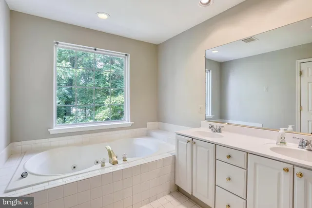 a bathroom with a tub a sink and a window
