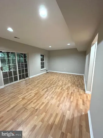 a view of empty room with wooden floor and window