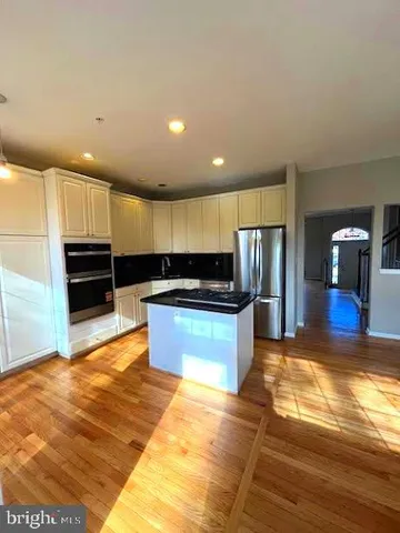 a kitchen with stainless steel appliances kitchen island granite countertop a stove and a sink