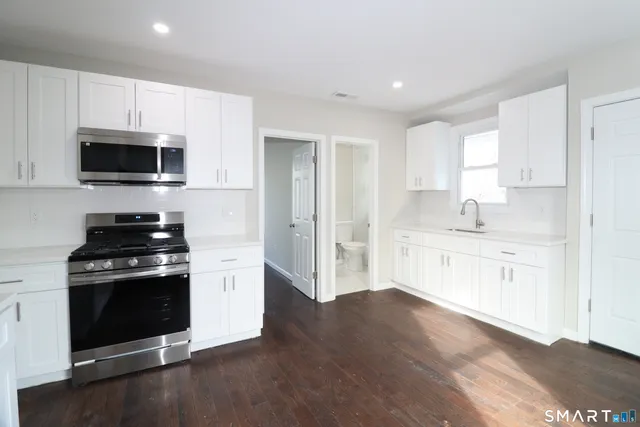 a kitchen with stainless steel appliances a stove microwave and sink