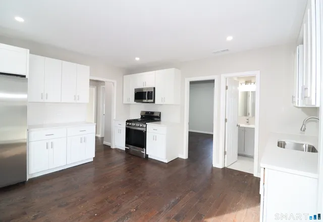 a kitchen with white cabinets and stainless steel appliances