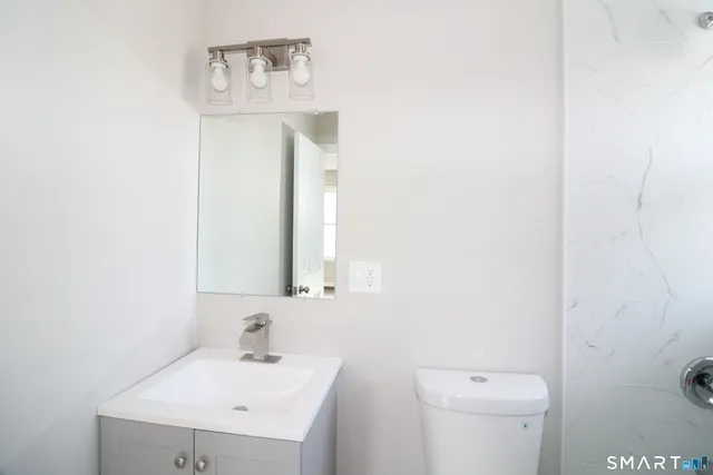 a bathroom with a sink a toilet and mirror