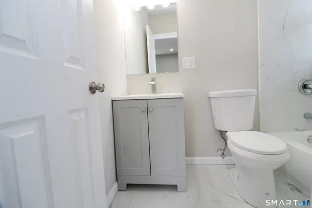 a bathroom with a toilet a sink and mirror