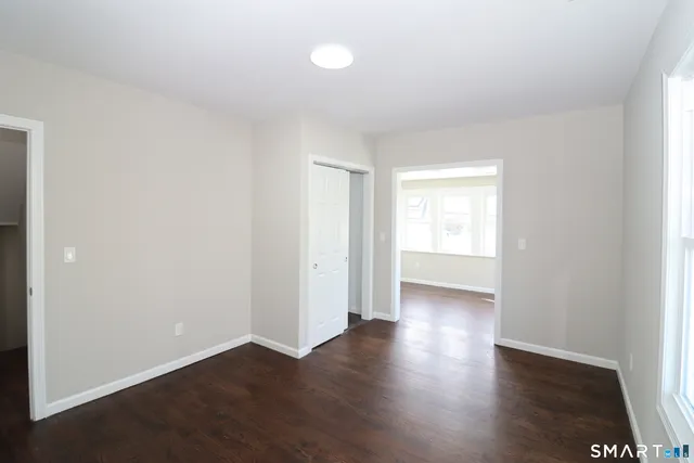 an empty room with wooden floor and window