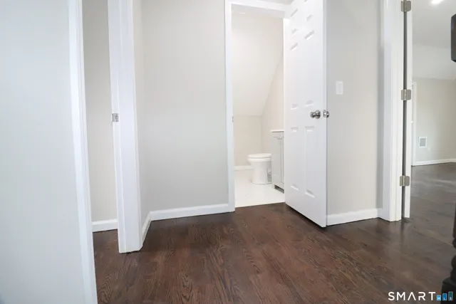 a big room with wooden floor and a bathroom view