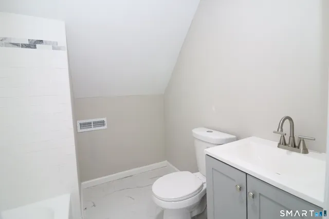 a bathroom with a toilet a sink and mirror