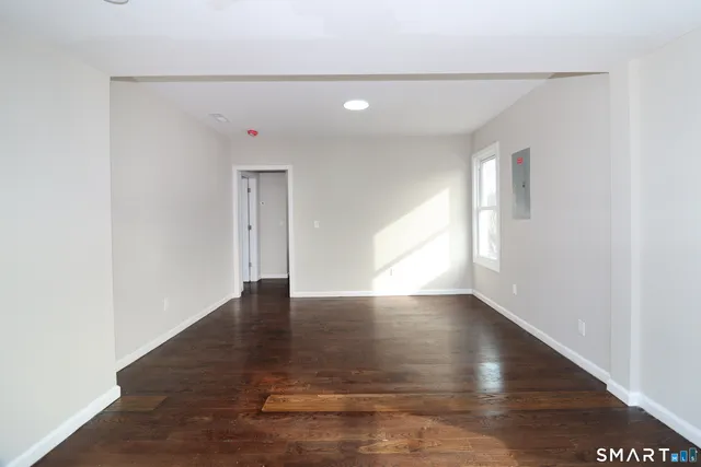 a view of an empty room with wooden floor
