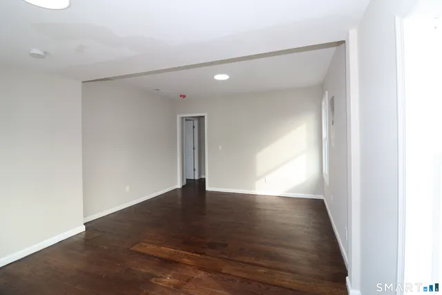 a view of an empty room with wooden floor