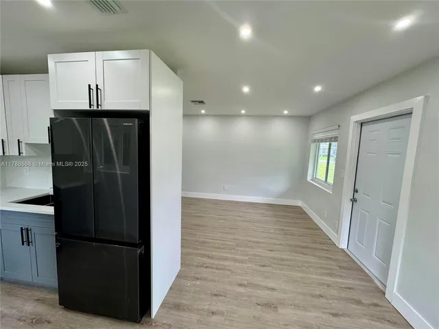 a view of a refrigerator in kitchen and wooden floor