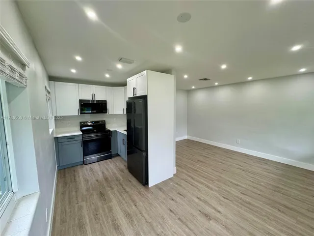 a kitchen with a refrigerator and a stove top oven