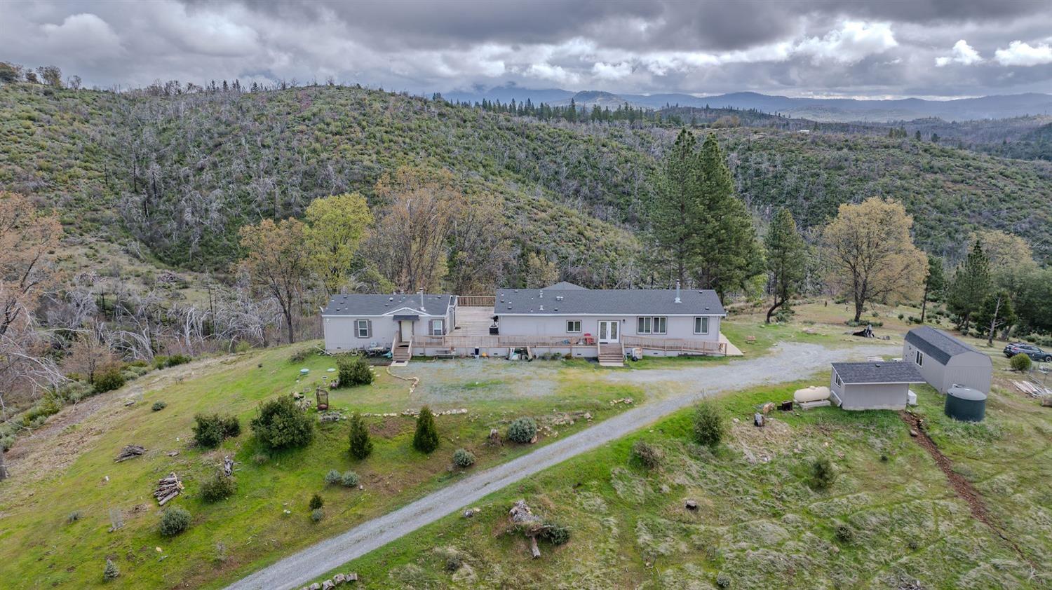 an aerial view of residential houses with outdoor space and trees