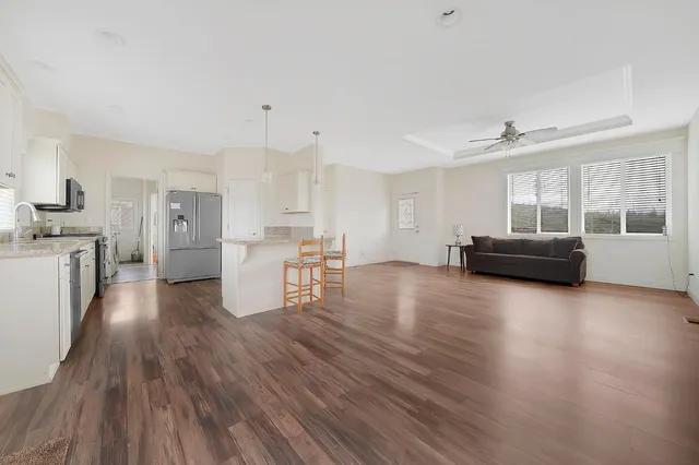 a view of a kitchen with furniture and wooden floor