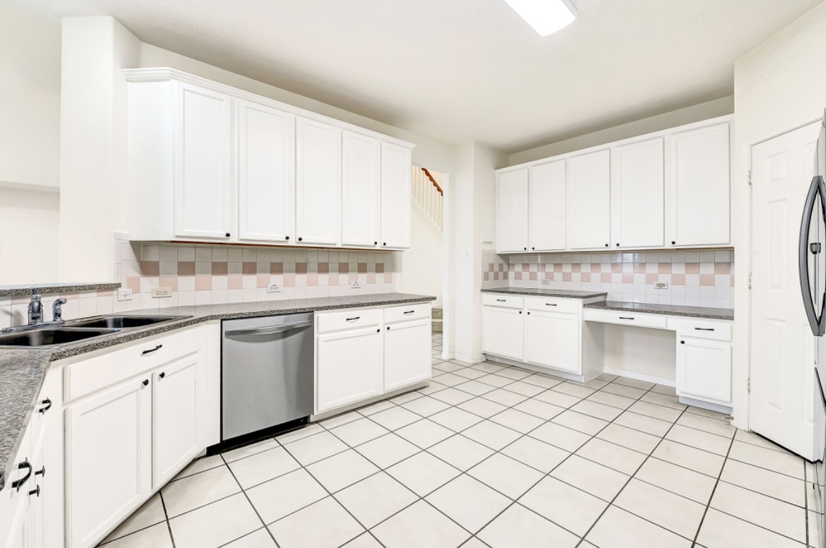 3306 Colleville Sur Mer Lane Spring, TX 77388 - Photo 14 of 40 a kitchen with granite countertop white cabinets stainless steel appliances a sink and a window