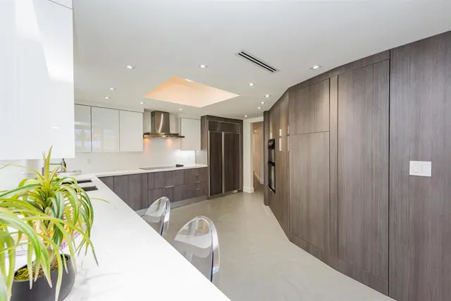 a kitchen with kitchen island granite countertop a sink a counter top space and stainless steel appliances
