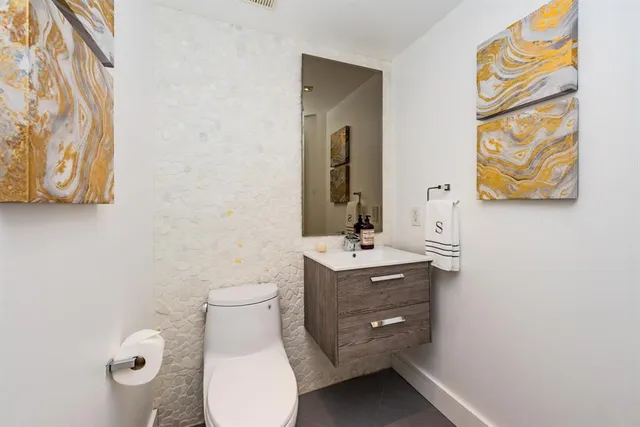 a bathroom with a toilet sink and mirror