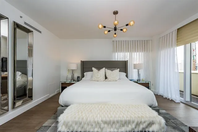 a bedroom with a large bed and a chandelier