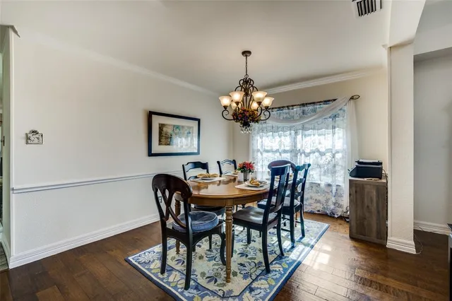 a dining room with furniture a chandelier and wooden floor