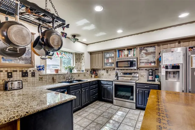 a kitchen with stainless steel appliances granite countertop a sink and a stove