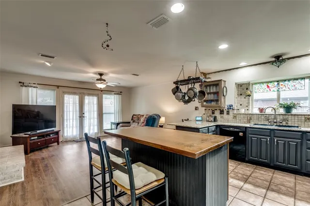 a kitchen with granite countertop a sink and a stove top oven with wooden floor