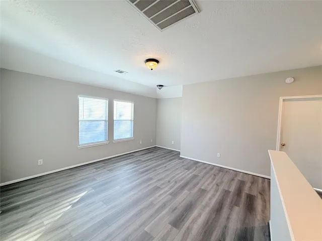 a view of empty room with wooden floor