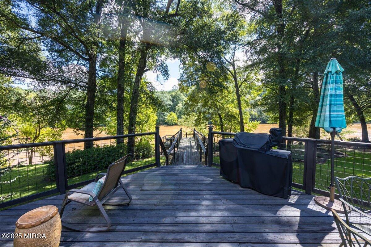11 River Trace Macon, GA 31210 - Photo 20 of 61 a view of a deck with couches table and chairs under an umbrella with wooden floor