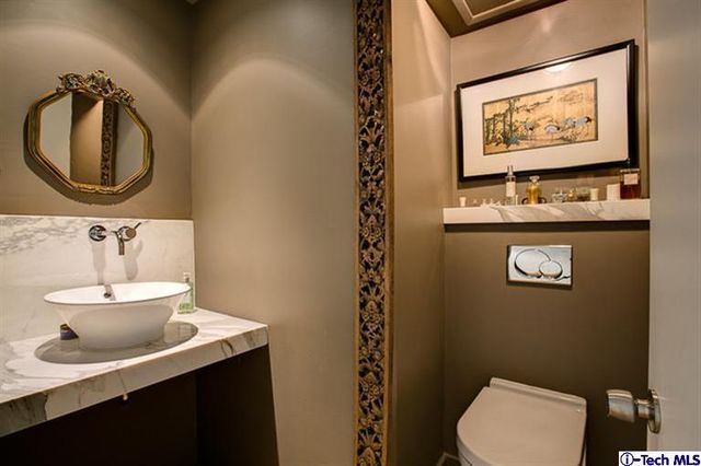 a white sink sitting under a bathroom mirror