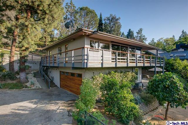 a view of a roof deck with table and chairs couches with wooden floor and fence