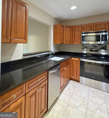 a kitchen with stainless steel appliances granite countertop a sink stove and microwave