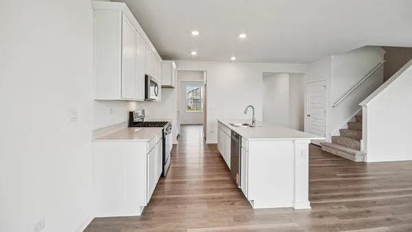 a kitchen with cabinets and wooden floor