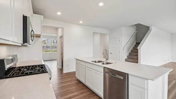 a kitchen with stainless steel appliances a stove a microwave a sink and cabinets