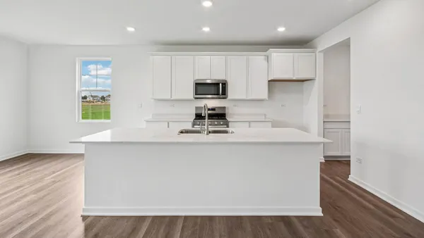 a kitchen with stainless steel appliances a stove a sink a refrigerator and a microwave