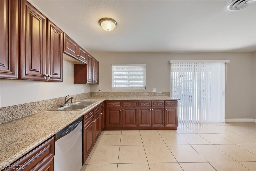 6321 Portola Road Las Vegas, NV 89108 - Photo 11 of 29 A well-appointed kitchen features ample cabinetry, stone countertops, and durable tile flooring.