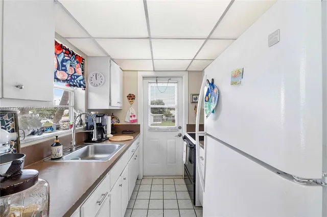 a kitchen with granite countertop a sink a counter top space and cabinets