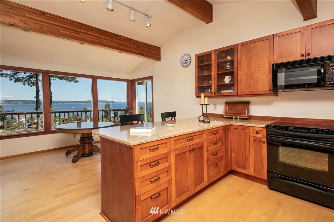 6188 Double Bluff Road Freeland, WA 98249 - Photo 23 of 40 a kitchen with stainless steel appliances granite countertop a stove a sink and a microwave