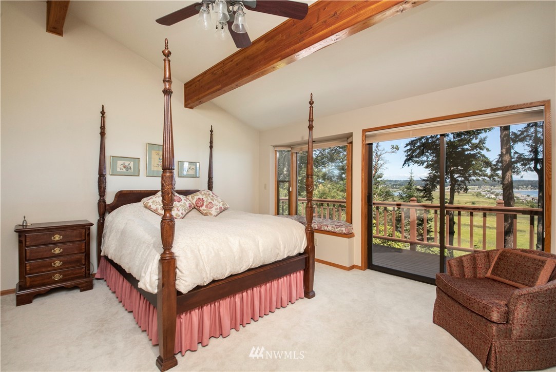 6188 Double Bluff Road Freeland, WA 98249 - Photo 28 of 40 a bedroom with a large bed and a chandelier
