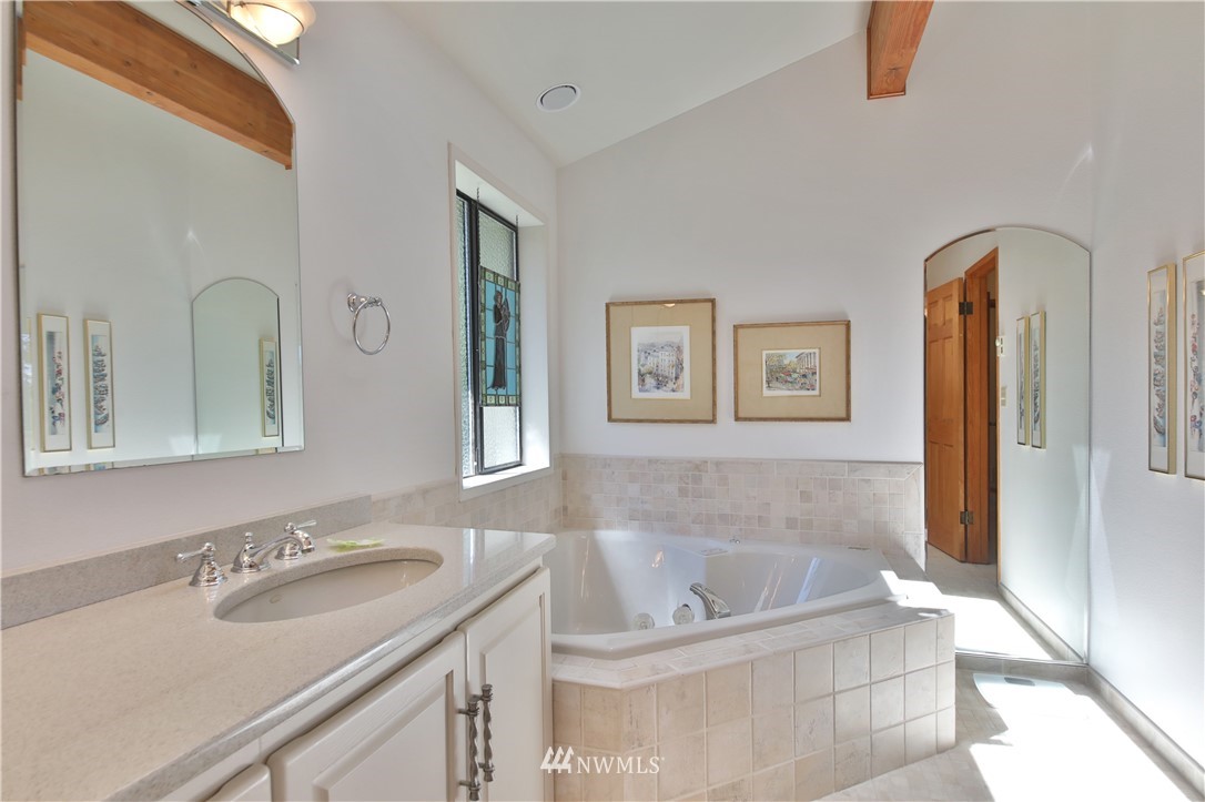 6188 Double Bluff Road Freeland, WA 98249 - Photo 30 of 40 a bathroom with a tub a sink and a mirror
